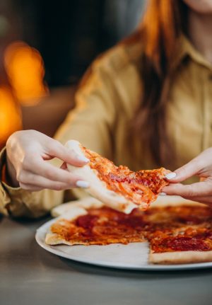 young-pretty-woman-eating-pizza-bar_1303-19910